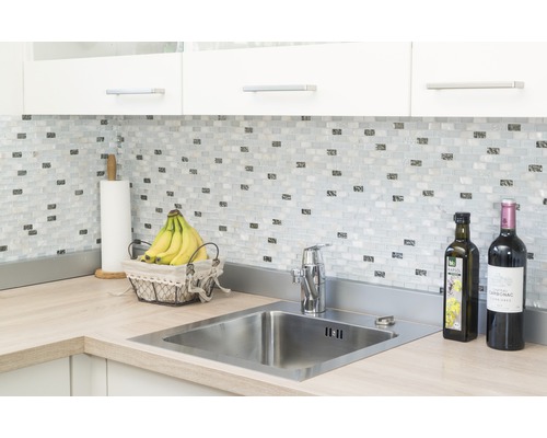 Kuchyňská scéna s dřezem, vodovodní baterií, mozaikovými dlaždicemi a pracovní deskou