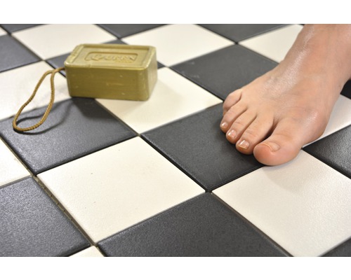 Scéna se šachovnicovými dlaždicemi, kusem mýdla a chodidlem