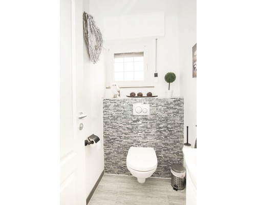 Moderní toaleta pro hosty s WC, mozaikovou stěnou a dekorací