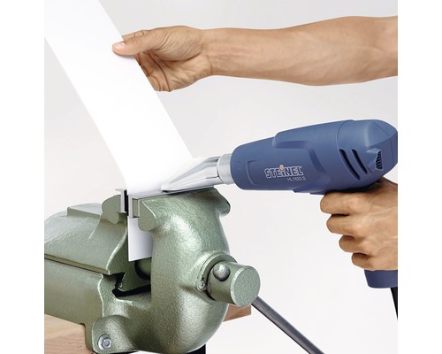 Horkovzdušná pistole se používá k opracování obrobku ve svěráku.