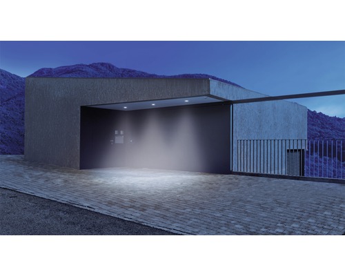 Osvětlený příjezd s moderní architekturou a horskou krajinou v pozadí