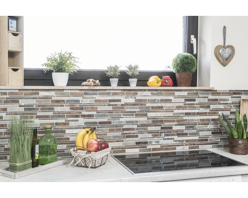 Kuchyňská scéna s mozaikovou stěnou, bylinkami, mísou s ovocem a varnou deskou