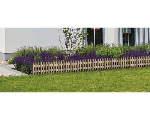 Dřevěný plot jako obruba záhonu v zahradě