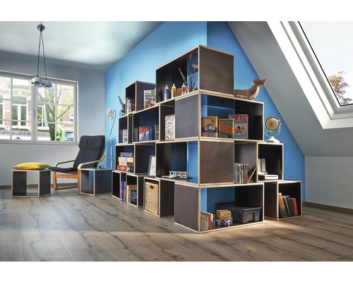 Obývací pokoj s modulárním regálovým systémem, křeslem a střešním oknem