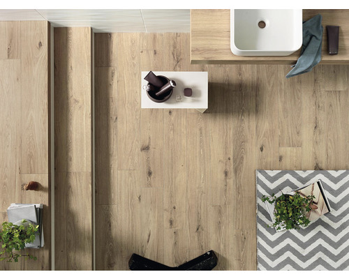 Koupelna se světlou dřevěnou podlahou, umyvadlem a dekoracemi