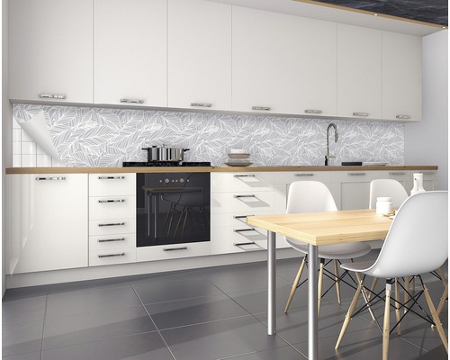 Moderní kuchyně s bílou kuchyňskou linkou, jídelním stolem a nástěnnými panely s listovým vzorem