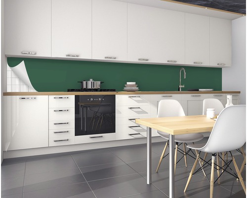 Kuchyňská scéna se zelenou fólií na kuchyňskou stěnu, bílými skříněmi a jídelním stolem.