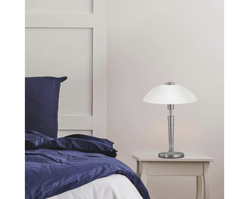 Noční lampa na nočním stolku vedle postele