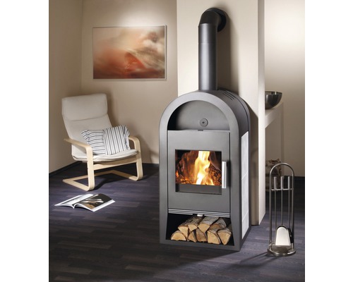 Krbová kamna s dřevem, krbové nářadí a křeslo v obývacím pokoji