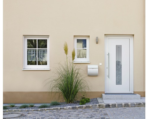 Fasáda obytného domu s vchodovými dveřmi, okny a poštovní schránkou