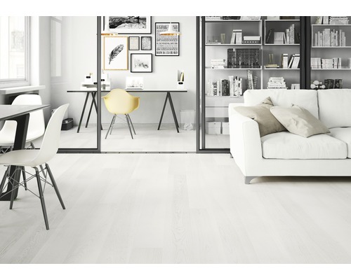 Světlá místnost s dřevěnou podlahou, stolem a pohovkou