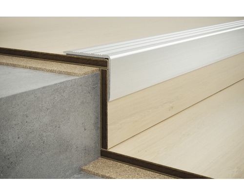 Kovový okraj schodu na betonovém a dřevěném podkladu