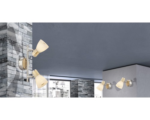 Obývací pokoj s několika nástěnnými svítidly se skleněnými stínidly a dřevěnými detaily.