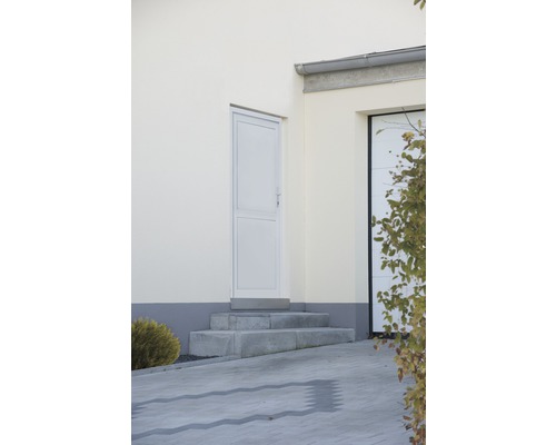 Venkovní pohled na dům se vstupními dveřmi, garáží a dlážděnou příjezdovou cestou.