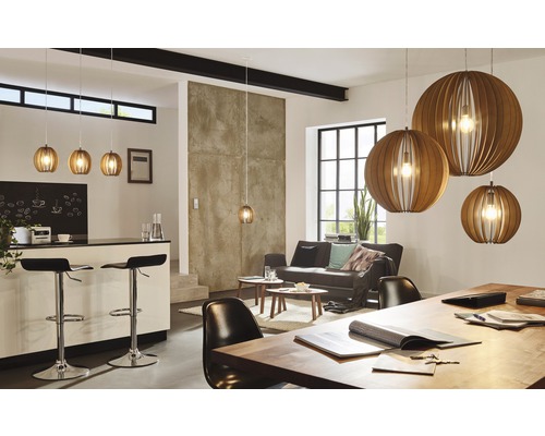 Světlý obývací pokoj s kuchyňským barem, pohovkou a několika dřevěnými závěsnými svítidly