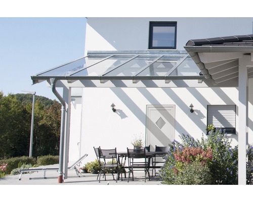 Terasa se skleněným zastřešením a zahradním nábytkem za slunného dne