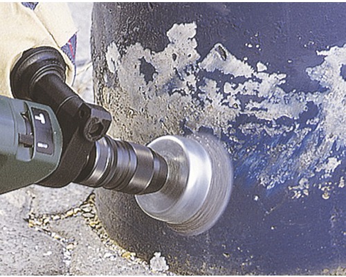 Vrtací stroj s kartáčovým nástavcem při práci na povrchu