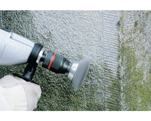 Kartáčový nástavec pro vrtačku používaný na kamenné zdi