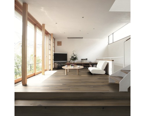 Světlý obývací pokoj s dřevěnou podlahou, schodištěm a okny