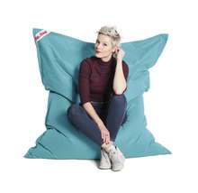 Žena sedí na tyrkysovém sedacím vaku Big Bag
