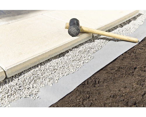 Dlažební kostky, štěrk a gumová palička na zahradní textilii