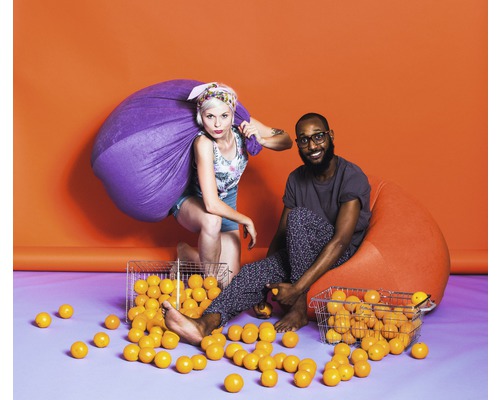 Dva lidé, jeden se sáčkem a jeden na sedacím vaku, obklopeni míčky.