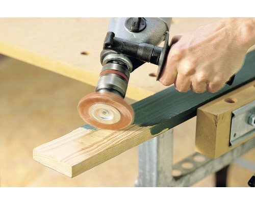 Osoba používá vrtačku s kartáčovým nástavcem k opracování kusu dřeva.