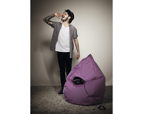 Scéna s mužem vedle fialového sedacího vaku a sluchátek