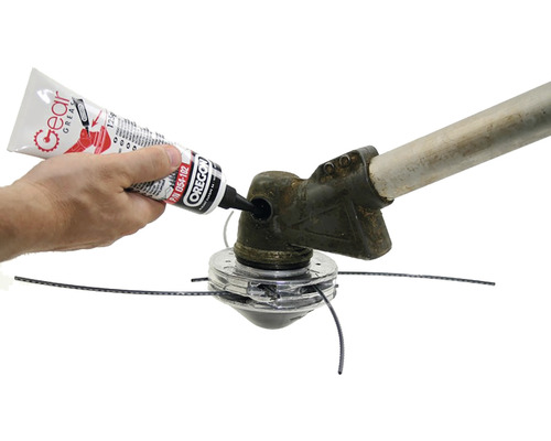 Osoba nanáší mazivo na vyžínač.