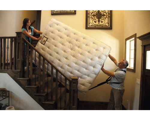 Dvě osoby nesou matraci po schodech