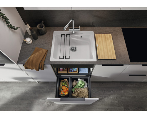 Kuchyňský dřez s baterií, krájecí deskou a systémem třídění odpadu v moderní kuchyni