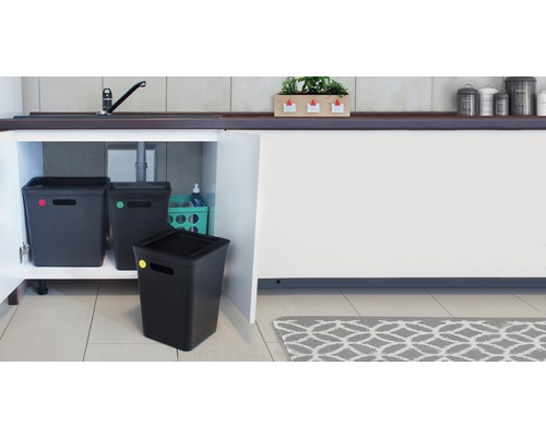 Tři černé odpadkové koše ve skříňce pod umyvadlem v kuchyni.