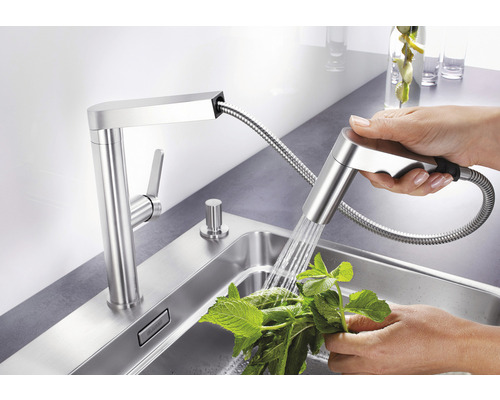 Kuchyňská baterie s sprchovou hlavicí a osobou myjící bylinky