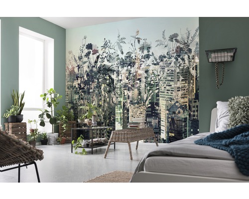 Světlá ložnice s fototapetou zobrazující městskou krajinu s květinovými prvky, doplněná rostlinami a světlým nábytkem.