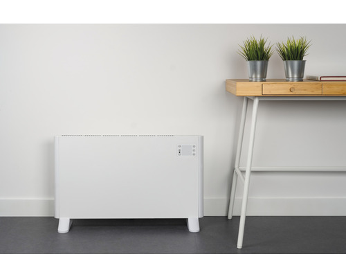 Elektrický konvektorový ohřívač vedle psacího stolu