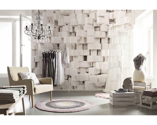 Světlá místnost s křeslem, věšákem na šaty, dekorací a geometrickou tapetou