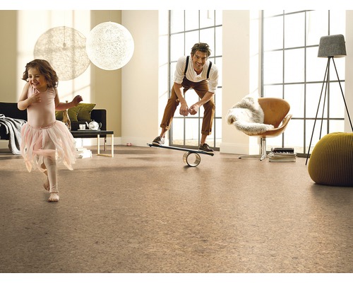 Obývací pokoj s korkovou podlahou, hrající si dívkou a mužem na balanční desce