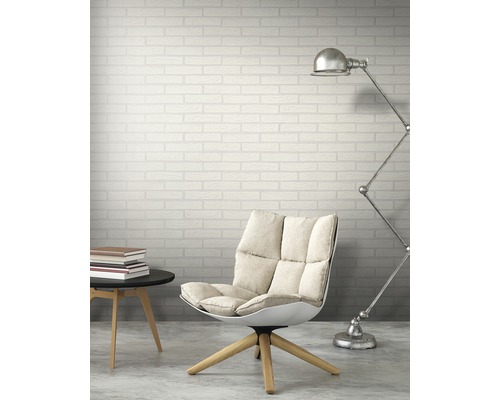 Scéna s křeslem, stojací lampou, odkládacím stolkem a zdí s cihlovým vzorem