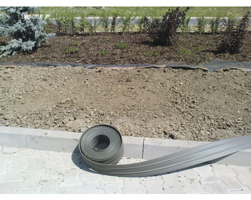 Plastový okraj trávníku vedle květinového záhonu