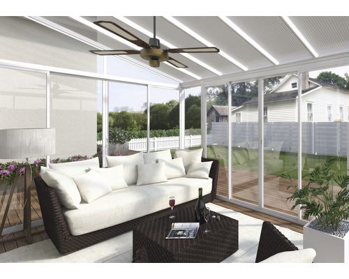 Obývací pokoj v zimní zahradě se sedačkou, stolem a stropním ventilátorem