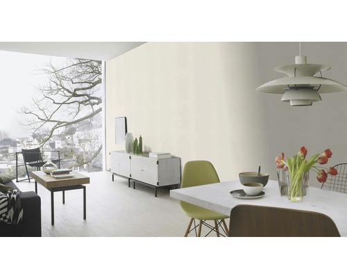 Moderní obývací pokoj se světlým odstínem na stěně, minimalistickým zařízením a velkými okny.