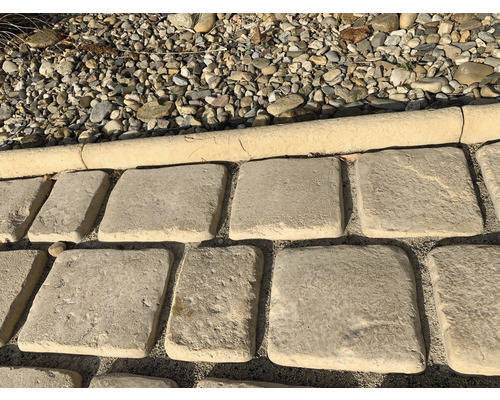 Čtvercové zahradní dlaždice z kamene vedle štěrku