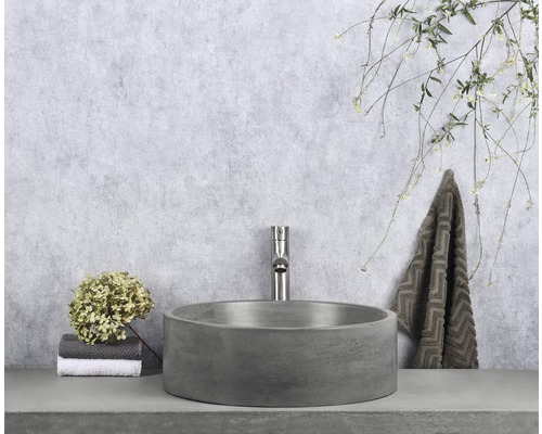 Koupelnová scéna s kulatým umyvadlem na desku, baterií a ručníkem