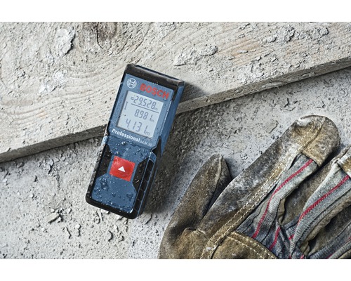 Dálkoměr Bosch Professional GLM 30 vedle pracovních rukavic