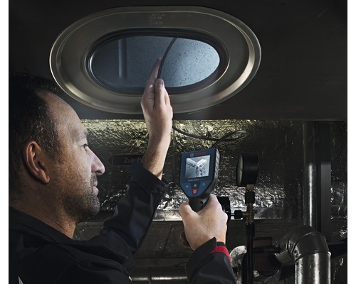 Muž používá inspekční kameru ke kontrole otvoru.