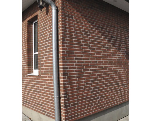 Exteriér domu s cihlovou fasádou a okapem