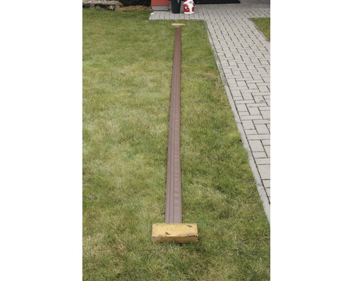 Dlouhý hnědý plastový profil na trávníku