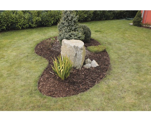 Zahradní úprava s kamenem, rostlinami a okrajem trávníku