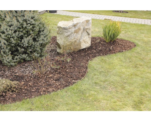 Zahradní krajina s okrasnou skálou, mulčovací kůrou a různými rostlinami