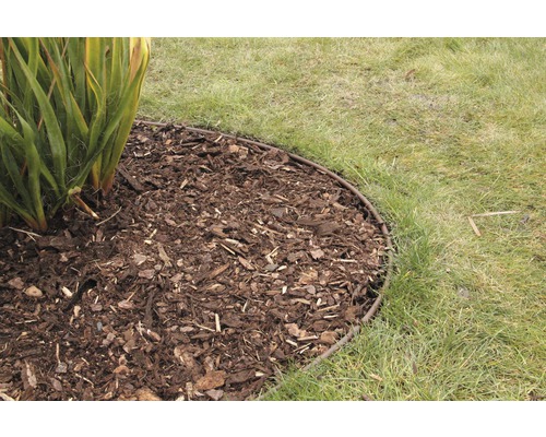 Kovový obrubník záhonu s mulčovací kůrou vedle trávníku